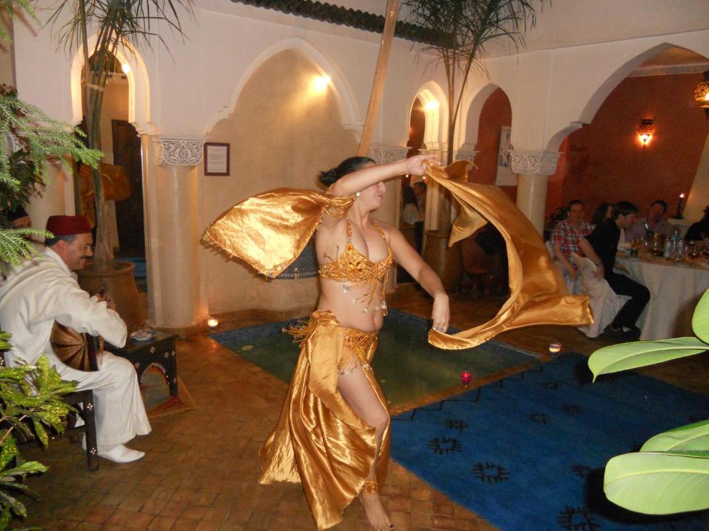 Une femme en robe dorée danse dans l'établissement Riad Morgane, à Marrakech