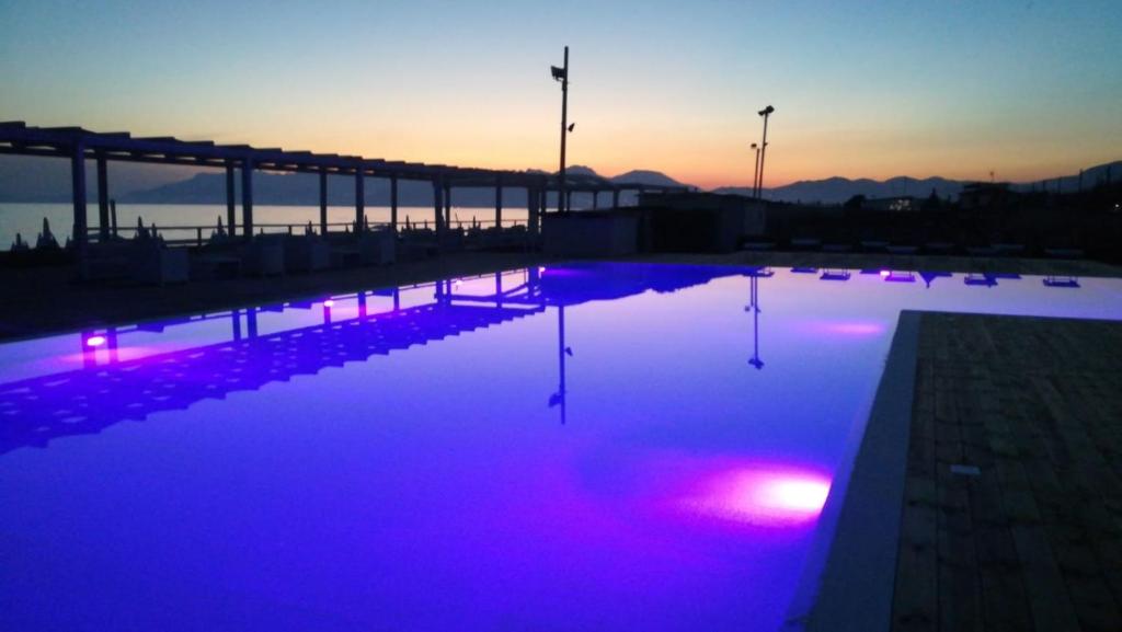 - une piscine avec des lumières violettes en face d'un pont dans l'établissement Sunrise Accessible Resort, à Battipaglia 29 autres photos