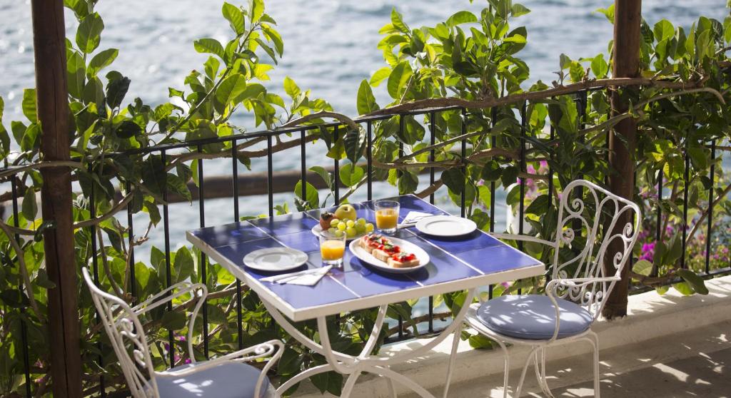 - une table bleue avec un bol de fruits dans l'établissement Hotel Umberto A Mare, à Ischia
