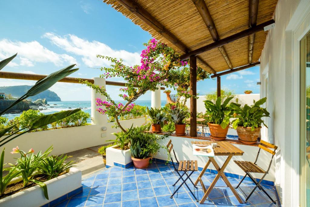 d'un balcon avec des plantes, une table et des chaises. dans l'établissement Hotel Umberto A Mare, à Ischia