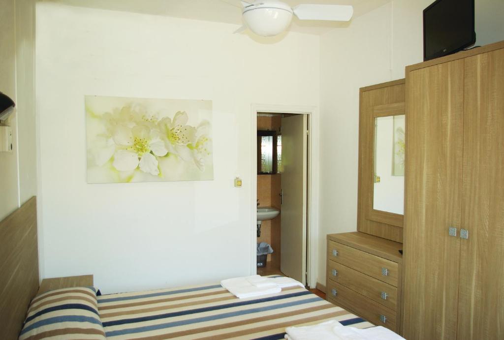 une chambre avec un lit, une commode et un miroir dans l'établissement Villaggio Benvivere, à Senigallia