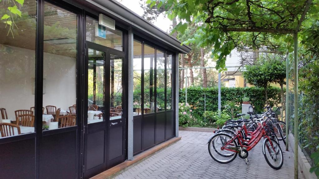 un groupe de vélos garés à l'extérieur d'un bâtiment dans l'établissement Hotel Acapulco, à Lignano Sabbiadoro