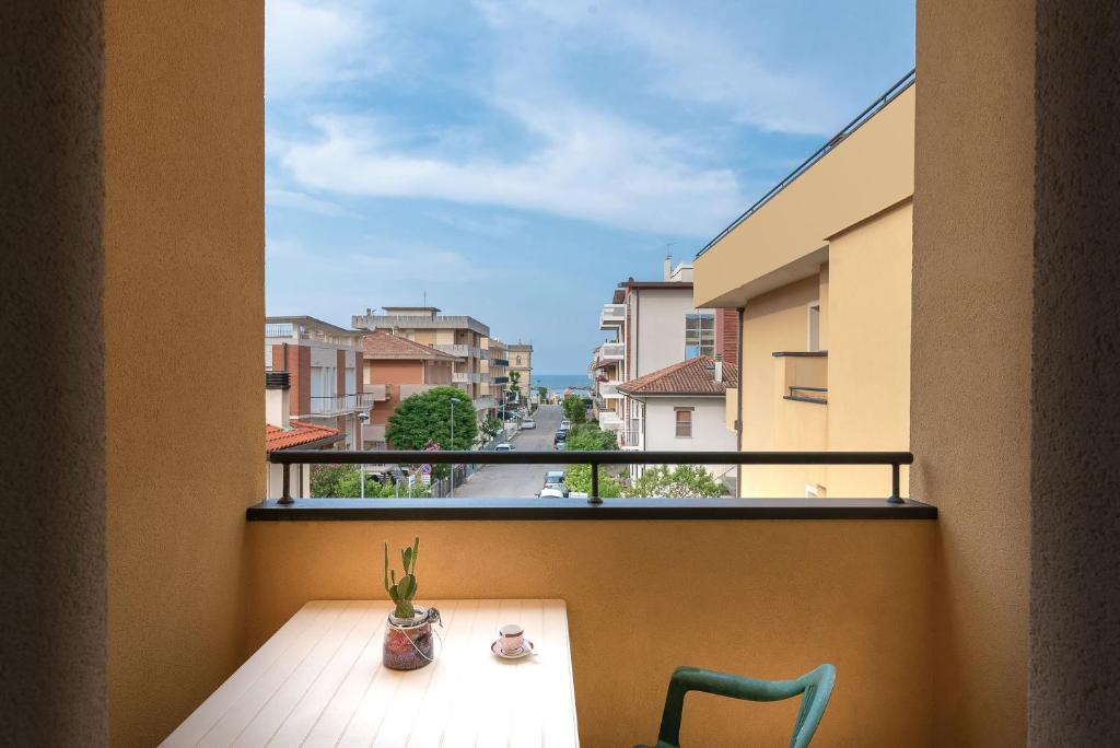 un balcon avec une table, des chaises et une fenêtre dans l'établissement Residence Cima, à Rimini