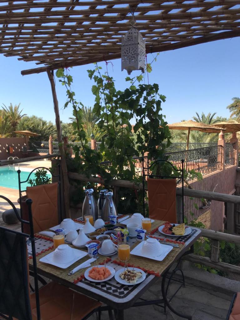 une table avec de la nourriture et des boissons sur une terrasse dans l'établissement Riad Dar Bab Todra, à Tinghir