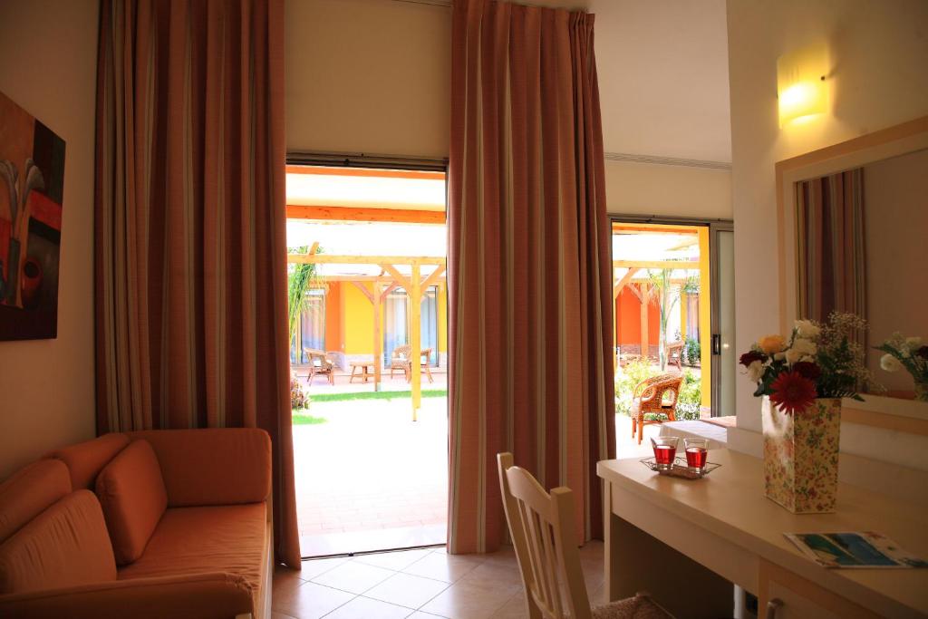 un salon avec un canapé, un bureau et une fenêtre dans l'établissement Hotel Baia Di Trainiti, à Vibo Valentia