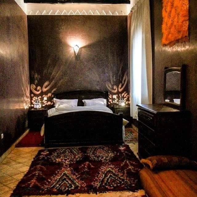 - une chambre avec un lit recouvert de bois sur le mur dans l'établissement Riad Sidi Hicham, à Marrakech