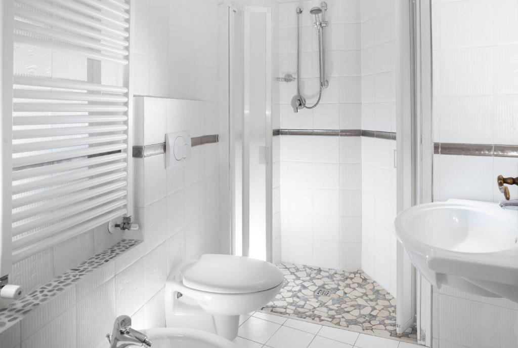 une salle de bain blanche avec toilettes et lavabo dans l'établissement SoleMare Hotel e Residence, à Misano Adriatico
