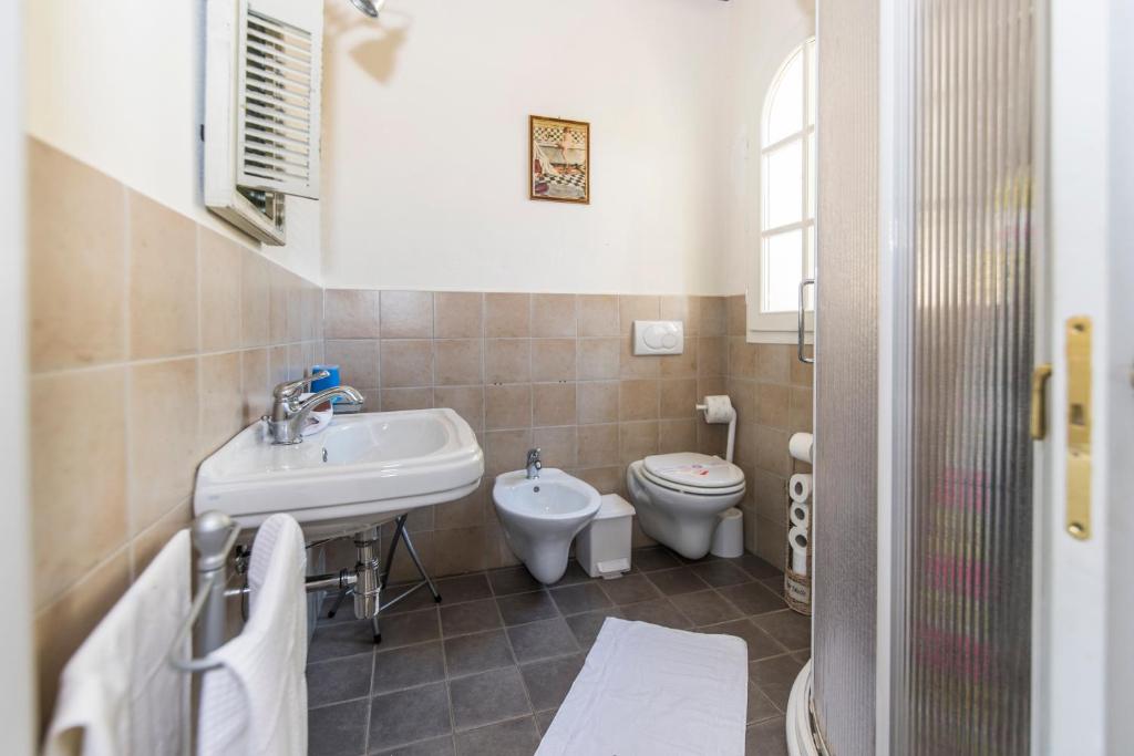 une salle de bain avec un lavabo et des toilettes dans l'établissement Valuable rustic Tuscan swimming pool, breathtaking view of Camaiore, à Camaiore