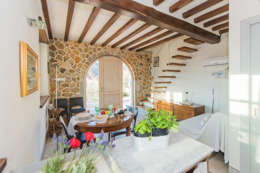 un salon avec une table et un mur en pierre dans l'établissement Valuable rustic Tuscan swimming pool, breathtaking view of Camaiore, à Camaiore