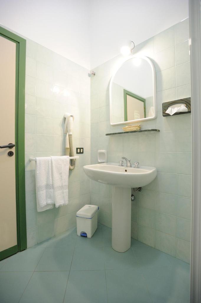 une salle de bain blanche avec un lavabo et un miroir dans l'établissement L'Approdo di Angelino, à Pizzolungo