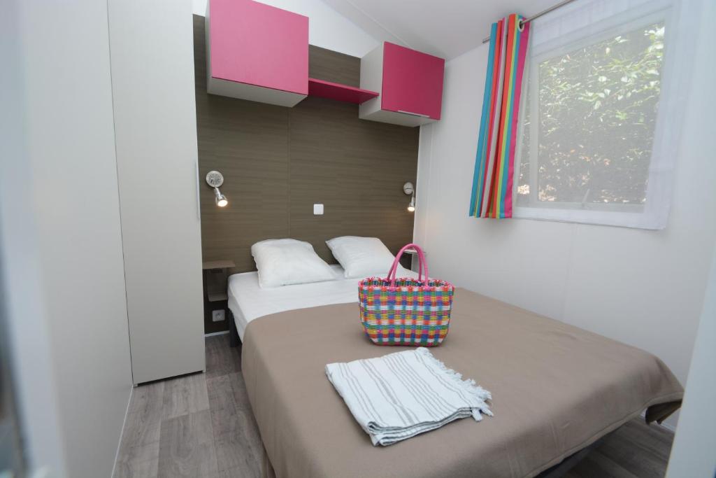 une chambre d'hôtel avec un lit avec un sac dans l'établissement Camping les Playes, à Six-Fours-les-Plages 27 autres photos