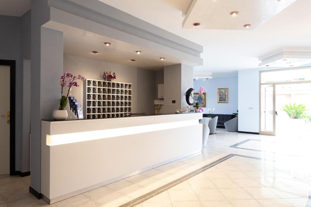 un hall d'entrée avec un comptoir avec des fleurs dessus dans l'établissement Hotel Abruzzo, à Pineto