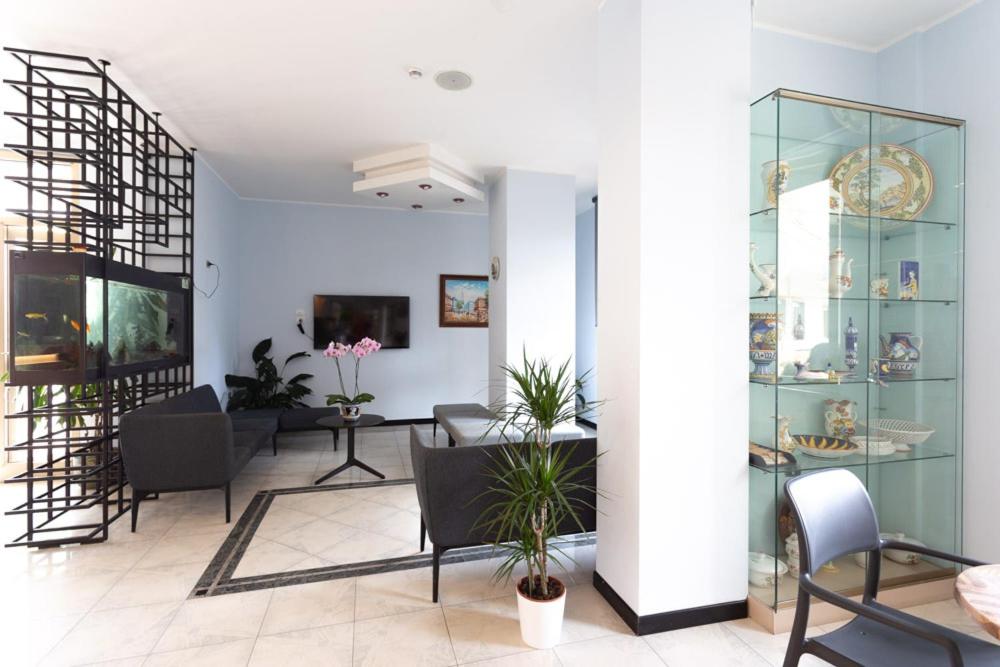 - un salon avec des étagères en verre, une table et des chaises dans l'établissement Hotel Abruzzo, à Pineto