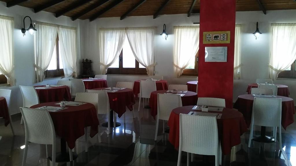 une salle à manger avec des tables et des chaises rouges et blanches dans l'établissement Hotel Parco Carabella, à Vieste