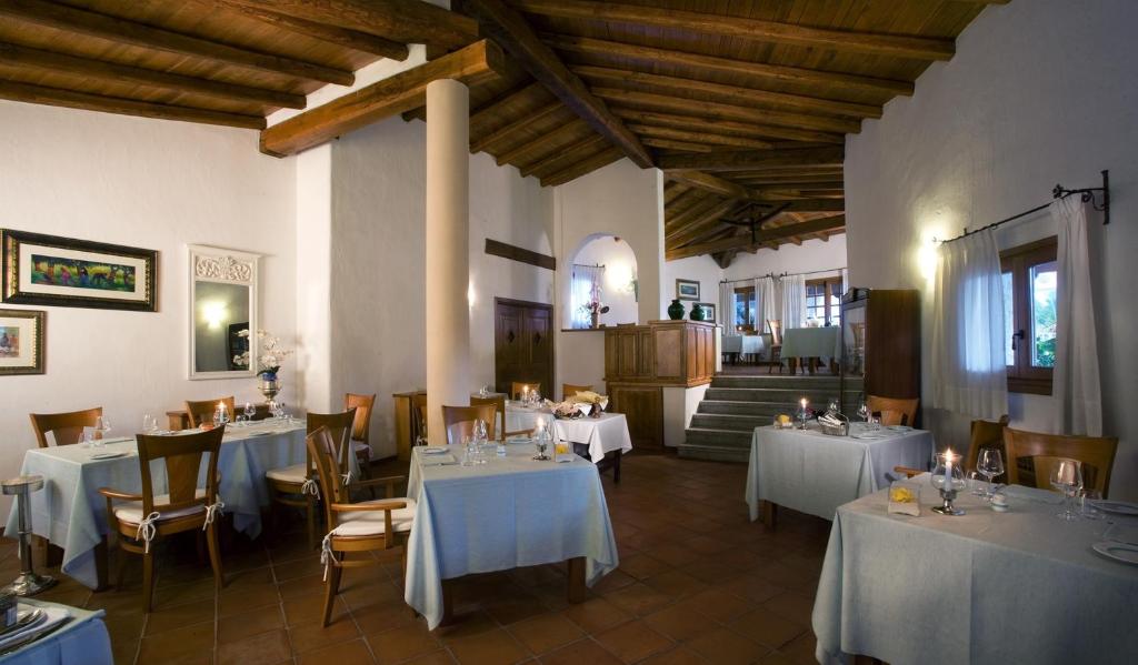 un restaurant avec des tables et des chaises avec une nappe blanche dans l'établissement Hotel Sporting, à Porto Rotondo