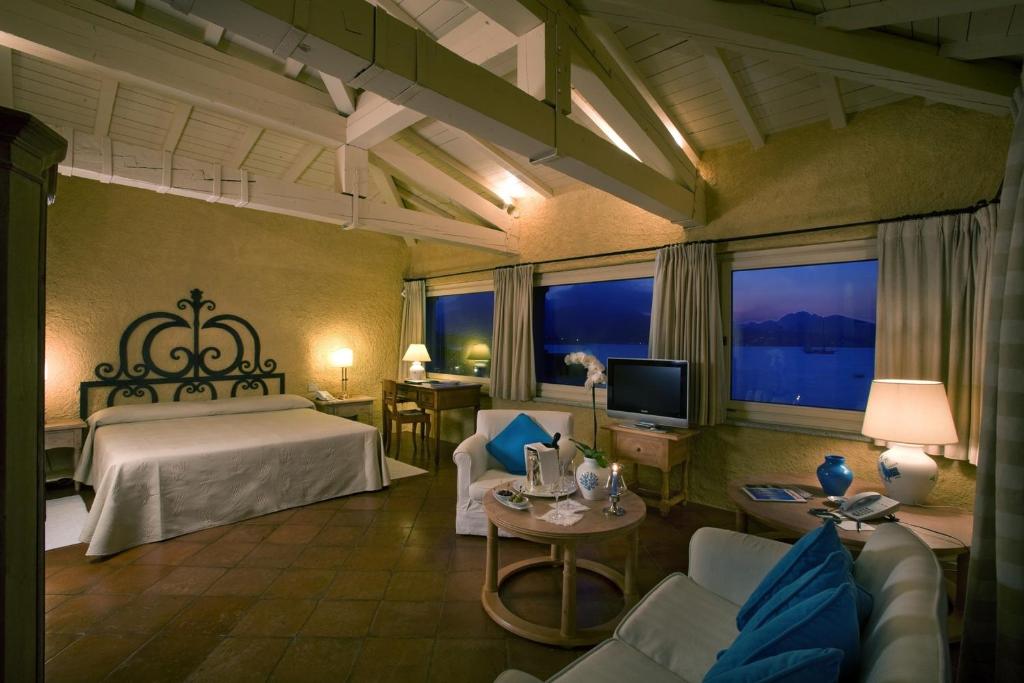 une chambre avec un lit et une télévision dans une pièce dans l'établissement Hotel Sporting, à Porto Rotondo