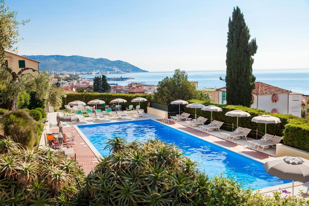 une piscine avec chaises longues et parasols dans l'établissement Hotel Metropol, à Diano Marina