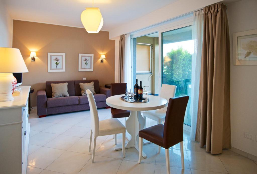 un salon avec une table, des chaises et un canapé dans l'établissement Taormina Villa Oasis Residence, à Taormine