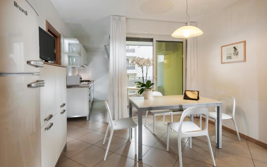 une cuisine et une salle à manger avec une table et des chaises dans l'établissement Appartamenti Aurora, à Bibione