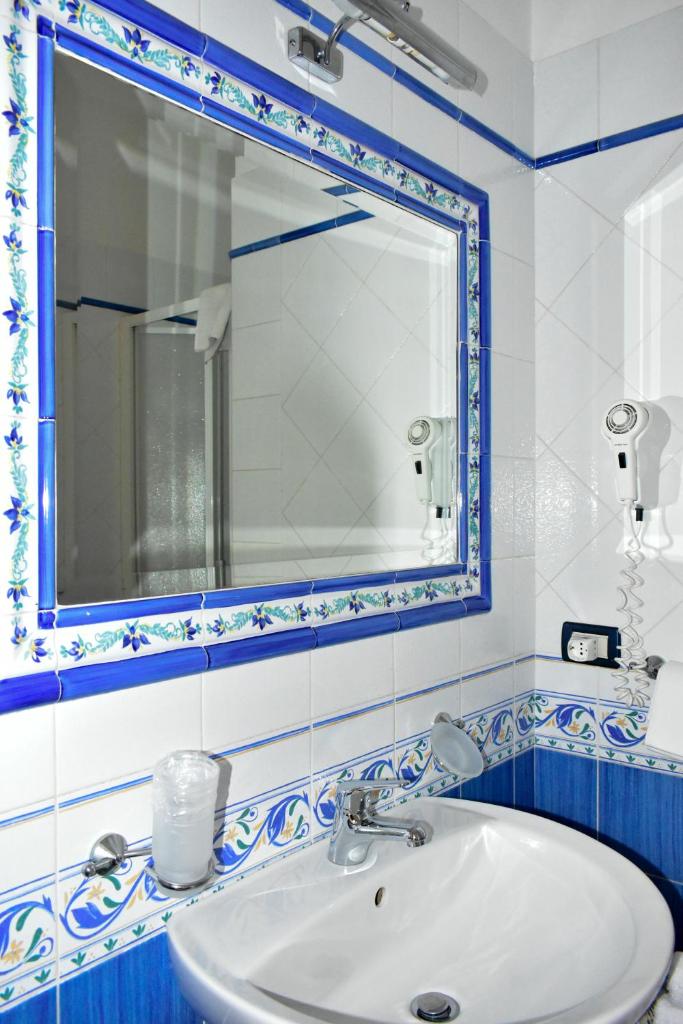 une salle de bain avec un lavabo blanc et un miroir dans l'établissement Hotel Amyclae, à Sperlonga