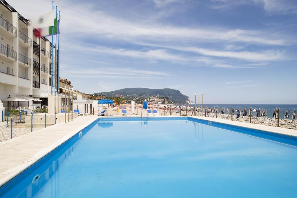 une grande piscine avec vue sur l'océan dans l'établissement Hotel Marcelli, à Numana