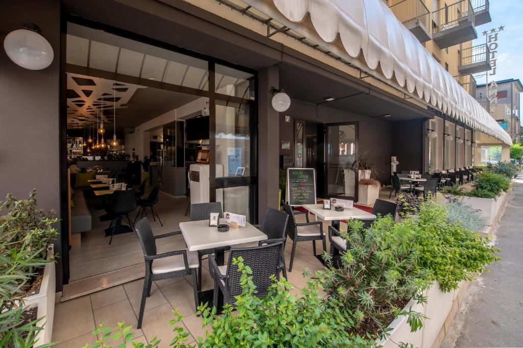 un restaurant avec des tables et des chaises à l'extérieur d'un bâtiment dans l'établissement Hotel Anny, à Lido di Jesolo