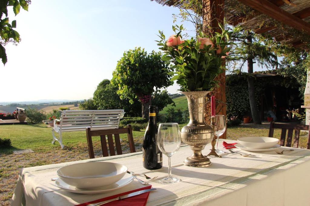 - une table avec un vase de fleurs et une bouteille de vin dans l'établissement Casa S.Paolo, à Rimini