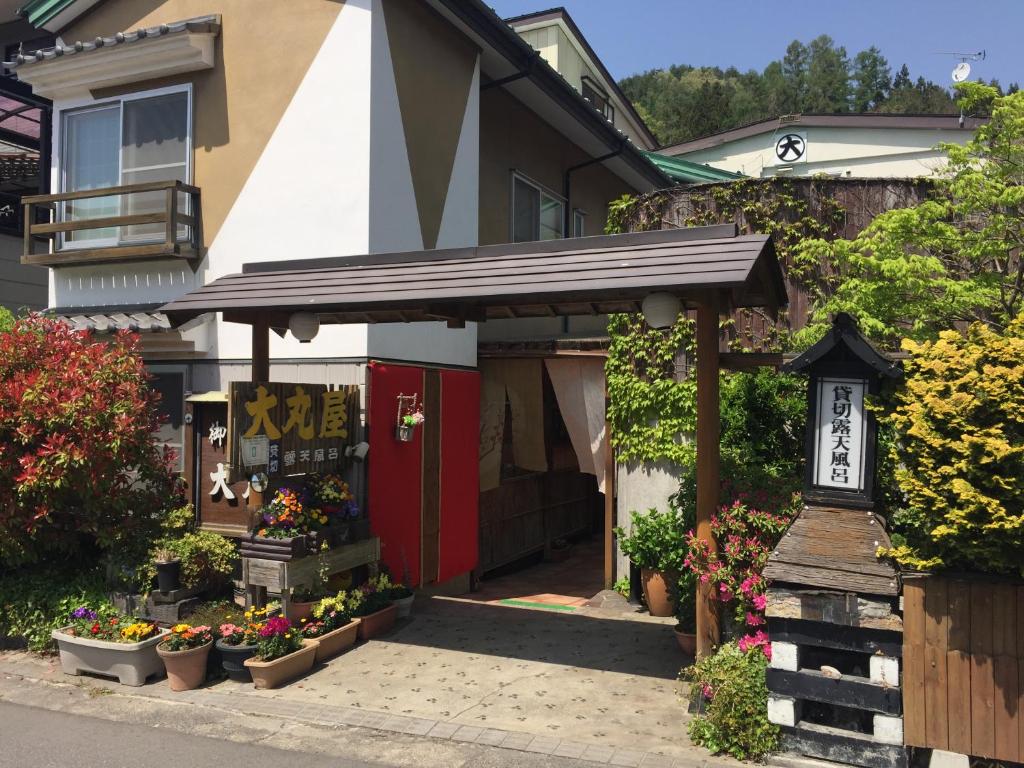 un magasin de jardin avec des fleurs devant une maison dans l'établissement Daymaruya Ryokan, à Yamanouchi
