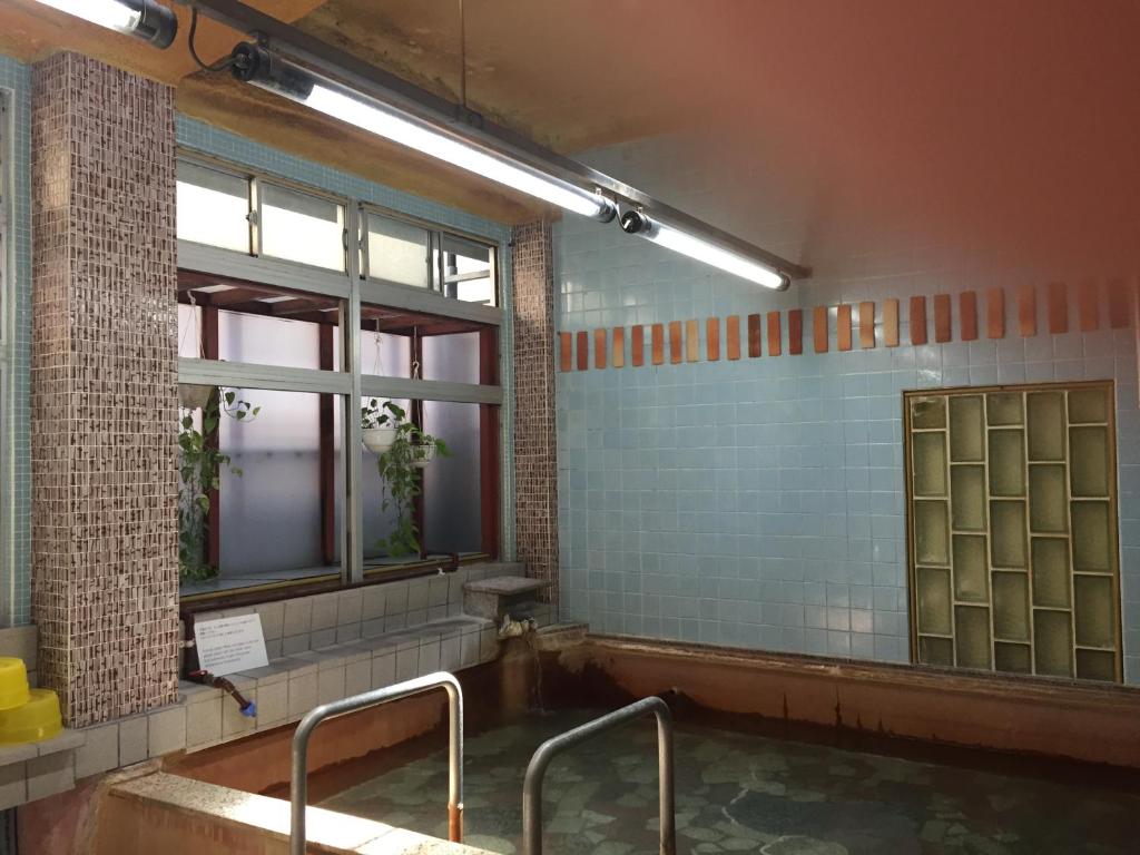 une salle de bain avec une baignoire et une fenêtre dans l'établissement Daymaruya Ryokan, à Yamanouchi