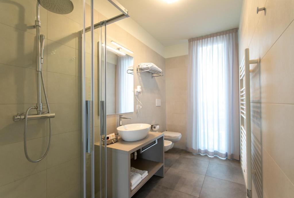 une salle de bain avec un lavabo, une douche et des toilettes dans l'établissement Residence Panama, à Lido di Jesolo