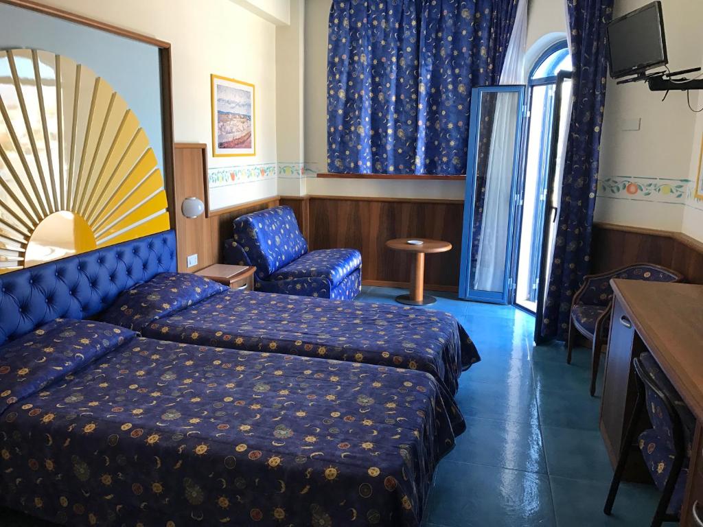 une chambre d'hôtel avec un lit et une chaise dans l'établissement Sporting Baia Hotel, à Giardini Naxos