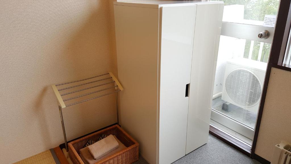 un réfrigérateur blanc dans une pièce avec une fenêtre dans l'établissement Granvillage Toya Daiwa Ryokan Annex, à Lac Tōya