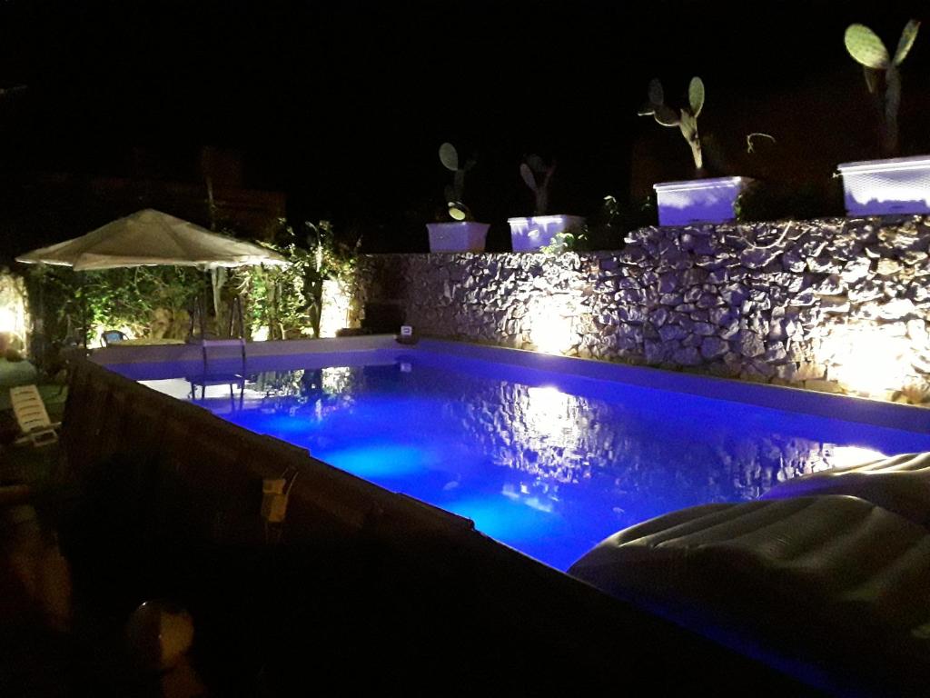une piscine la nuit avec des lumières bleues dans l'établissement Villa sul porto, à San Vito Lo Capo