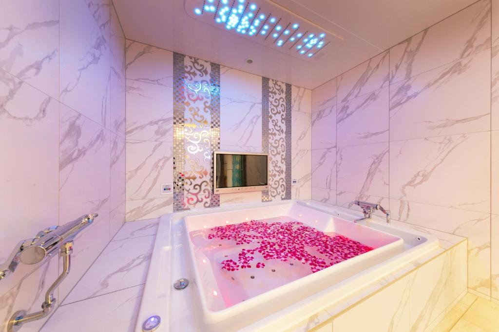 une salle de bain avec une baignoire remplie de fleurs roses dans l'établissement i RESORT ARTIA Luxury Gifu (Adult Only), à Gifu 49 autres photos