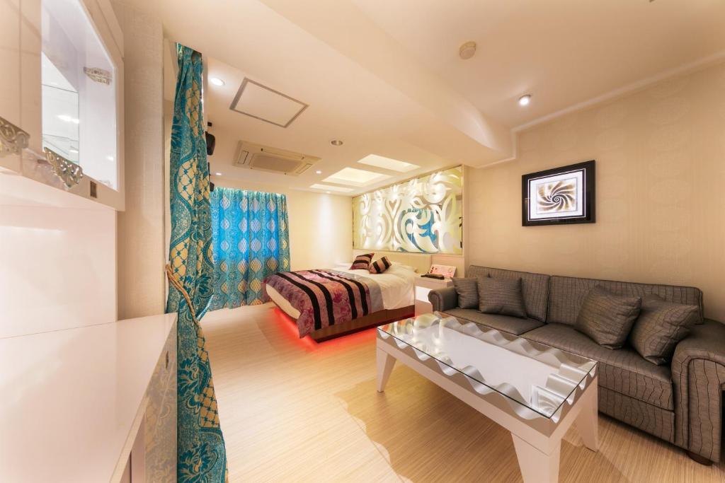 un salon avec un canapé et un lit dans l'établissement i RESORT ARTIA Luxury Gifu (Adult Only), à Gifu