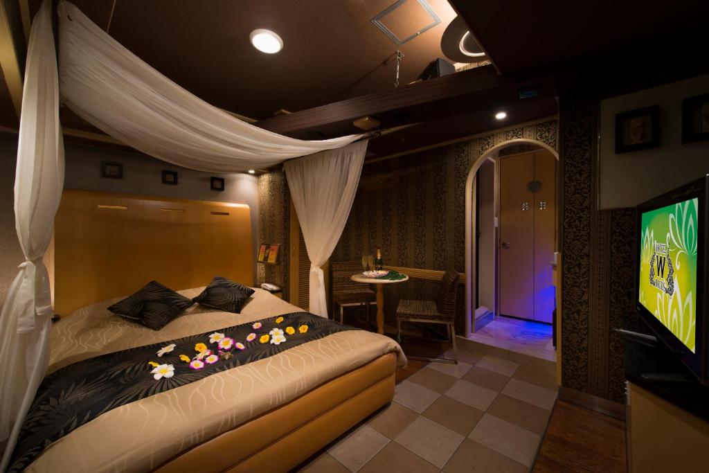 une chambre avec un lit et une télévision dans une pièce dans l'établissement Hotel W-BAGUS -W GROUP HOTELS and RESORTS-, à Tokyo