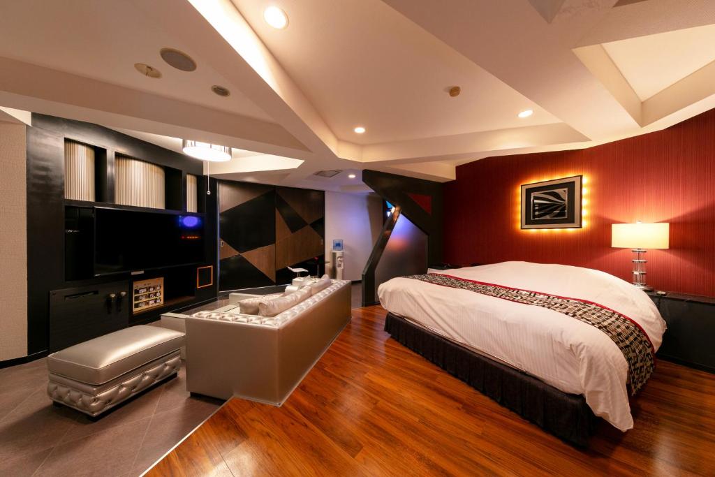 une chambre avec un grand lit et une télévision à écran plat dans l'établissement Hotel Eldia Yamanashi (Adult Only), à Fuefuki