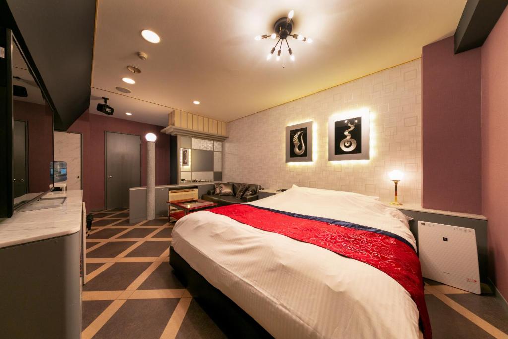 une chambre avec un grand lit dans une pièce dans l'établissement Hotel Eldia Yamanashi (Adult Only), à Fuefuki