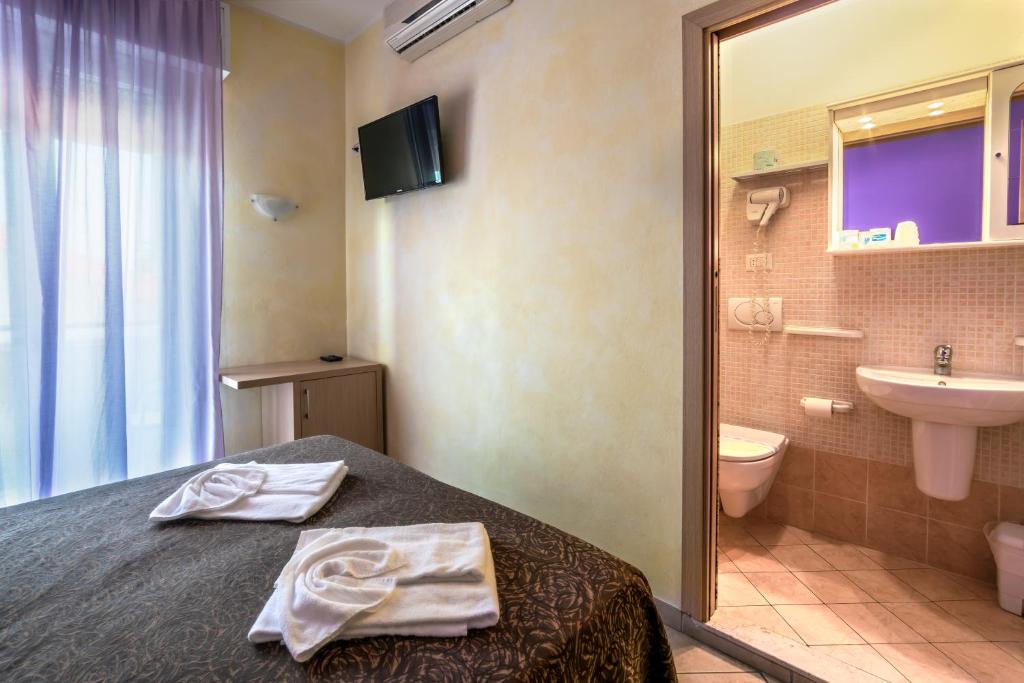 une salle de bain avec un lit, un lavabo et des toilettes dans l'établissement Hotel Rubens, à Rimini