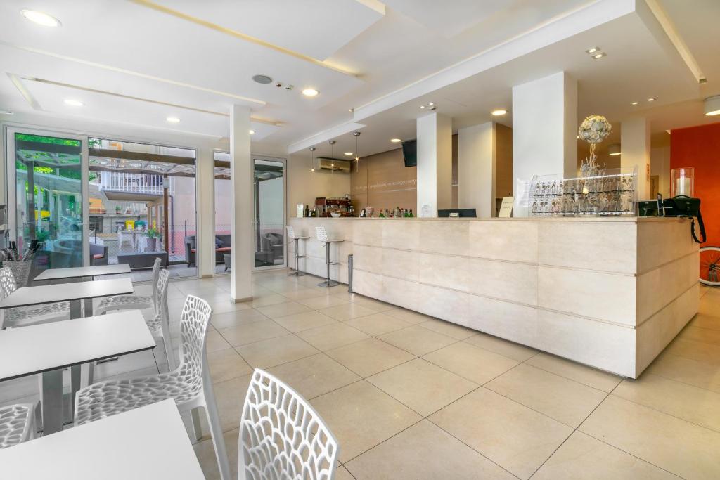 un restaurant avec des tables, des chaises et un comptoir dans l'établissement Hotel Rubens, à Rimini
