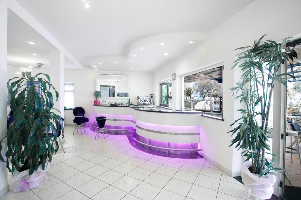 un bar dans un restaurant à l'éclairage violet dans l'établissement Hotel Blues, à Cervia