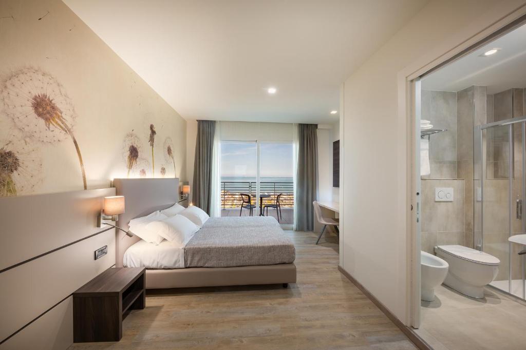 - une chambre avec un lit et une salle de bains dans l'établissement Hotel Tritone, à Caorle