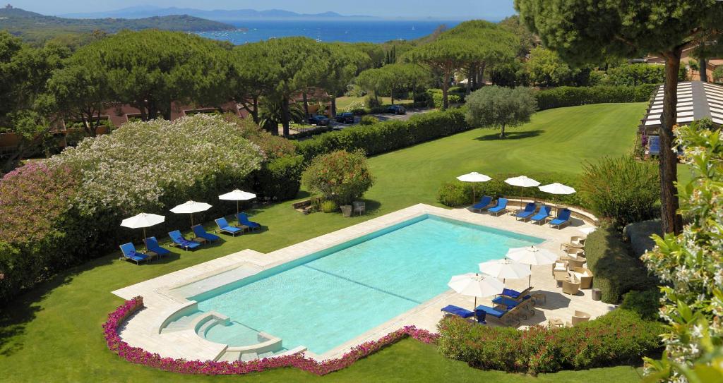 une vue aérienne d'une piscine avec chaises et parasols dans l'établissement Gallia Palace Hotel - Relais & Châteaux, à Punta Ala