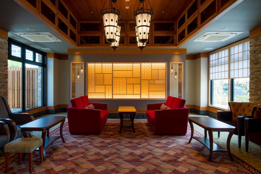 un hall avec des chaises et des tables rouges et des fenêtres dans l'établissement Unzen Kyushu Hotel, à Unzen