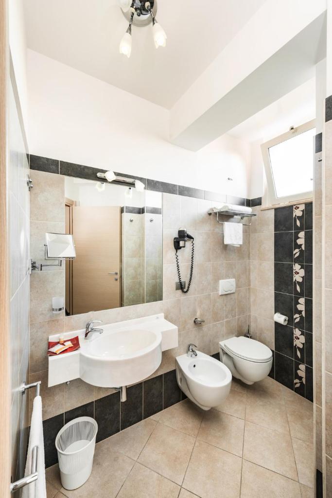 une salle de bains avec lavabo, baignoire et toilettes dans l'établissement Hotel Fenix, à San Benedetto del Tronto