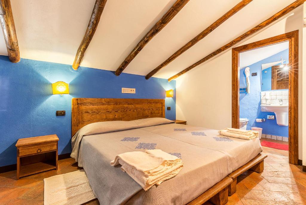 une chambre avec un lit et un mur bleu dans l'établissement Hotel Santa Maria, à Santa Maria Navarrese