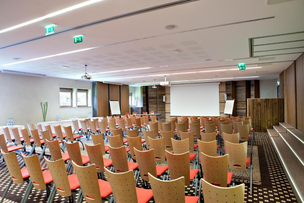 une salle vide avec rangées de chaises et podium dans l'établissement Au Coeur du Village, à La Clusaz 37 autres photos