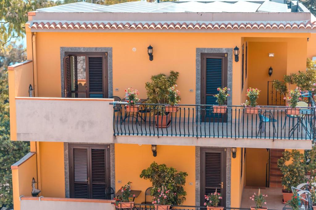 une maison orange avec un balcon avec des plantes dans l'établissement Residence Villa Il Glicine, à Taormine