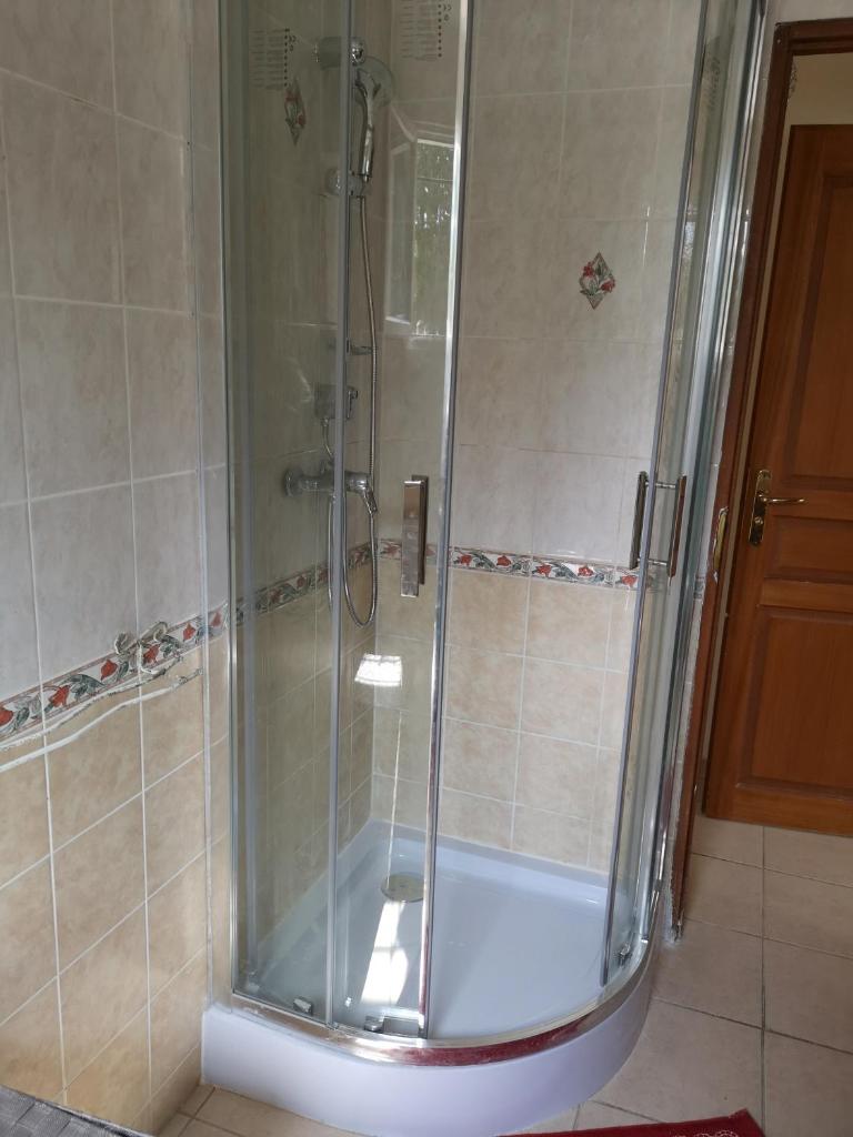 une douche avec une porte vitrée dans une salle de bain dans l'établissement gîte de la Rose, à Draguignan