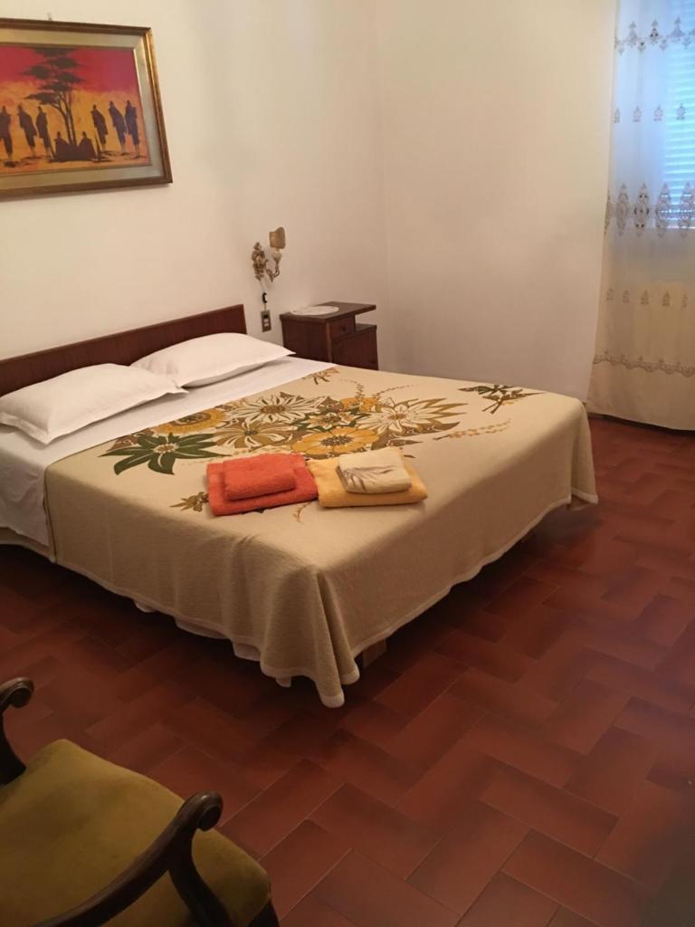 une chambre avec un lit avec deux serviettes dessus dans l'établissement CASA DEGLI ZII appartamento Letizia, à Luni